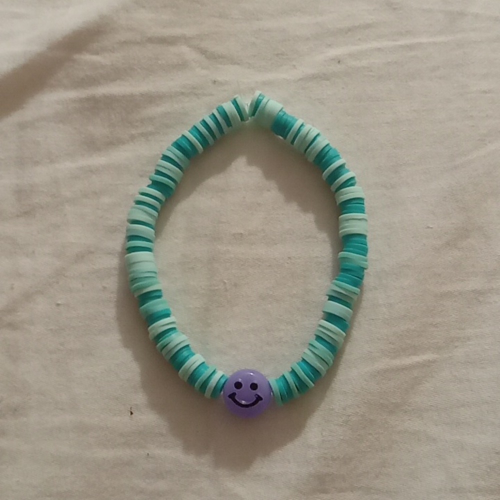 Green bracelet with purple smiley face